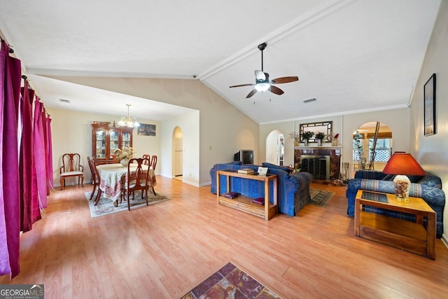 living room with ceiling fan with notable chandelier, lofted ceiling with beams, light hardwood / wood-style floors, and ornamental molding