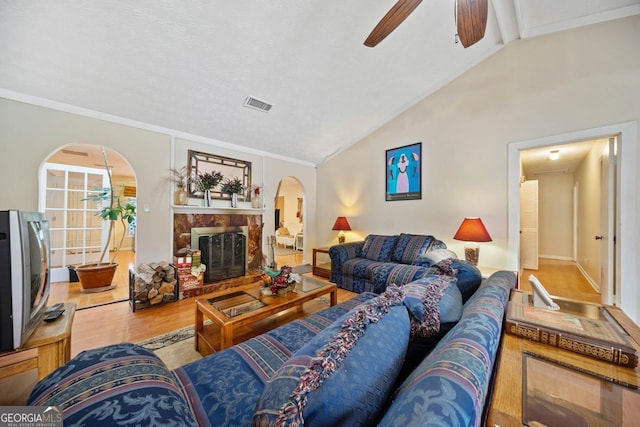 living room with ceiling fan, high vaulted ceiling, wood-type flooring, and ornamental molding