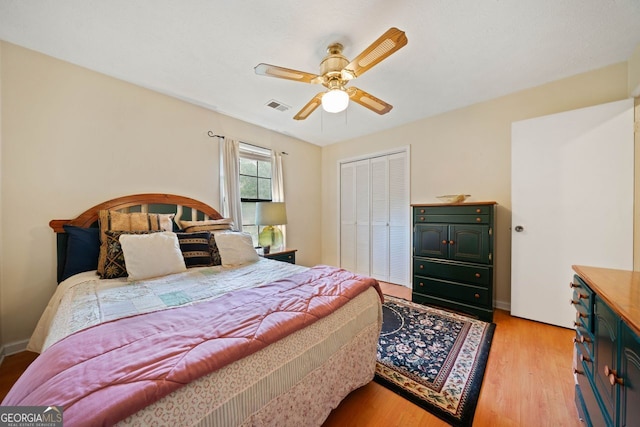 bedroom featuring light hardwood / wood-style floors, a closet, and ceiling fan