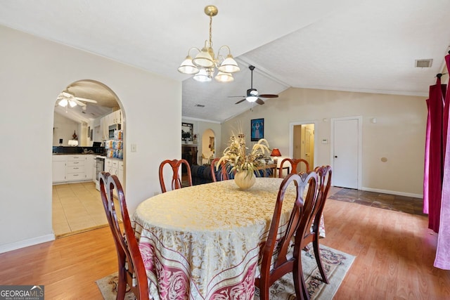 dining area featuring ceiling fan with notable chandelier, light hardwood / wood-style floors, and lofted ceiling