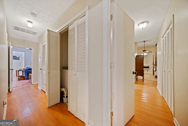 hall with hardwood / wood-style floors and a textured ceiling