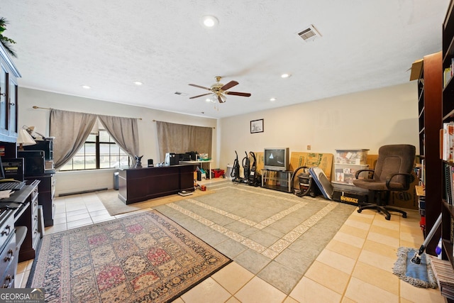 interior space with light tile patterned floors, a textured ceiling, and ceiling fan