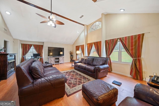 living room with plenty of natural light, ceiling fan, light wood-type flooring, and high vaulted ceiling