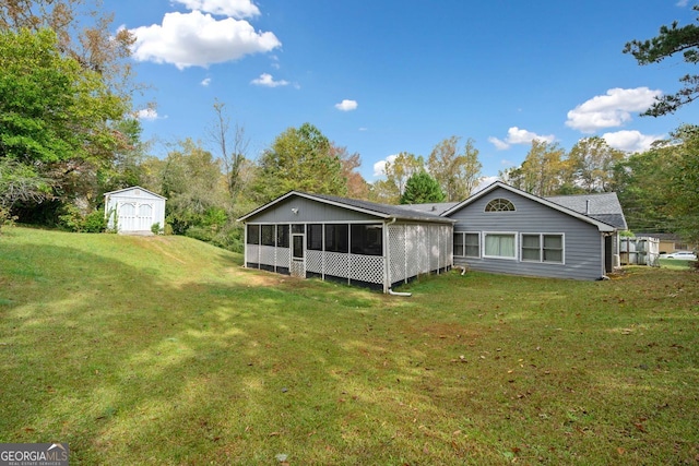 rear view of house with a sunroom, a storage unit, and a lawn