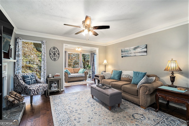 living room featuring dark wood-type flooring, a premium fireplace, a textured ceiling, ceiling fan, and crown molding