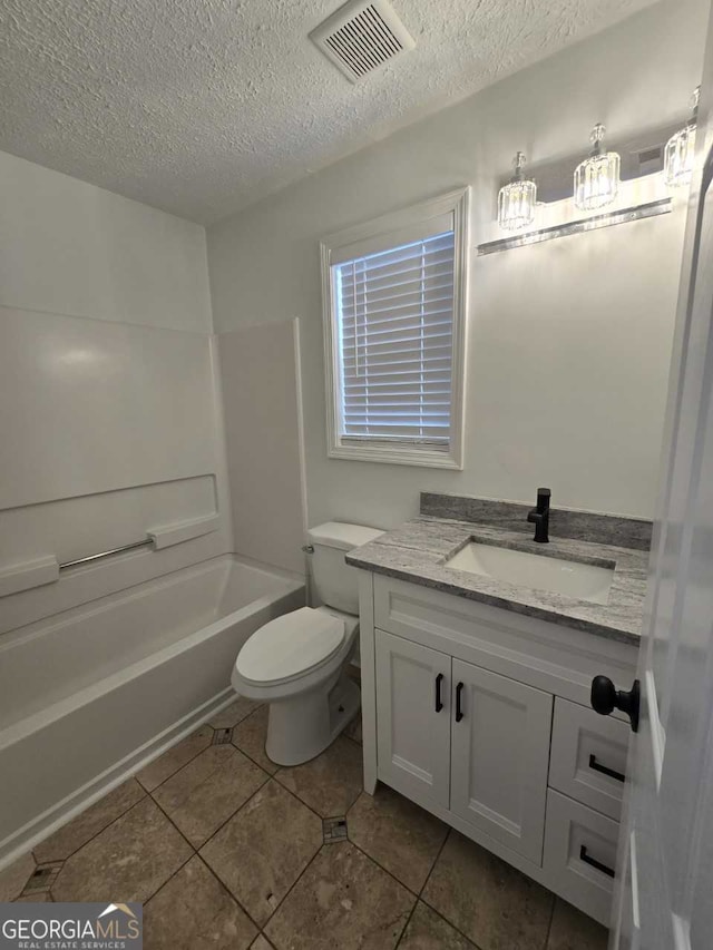 full bathroom featuring tile patterned flooring, vanity, toilet, and a textured ceiling