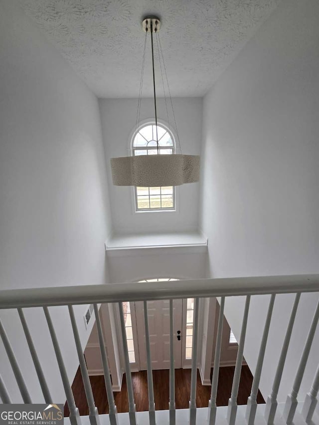 staircase featuring wood-type flooring and a textured ceiling