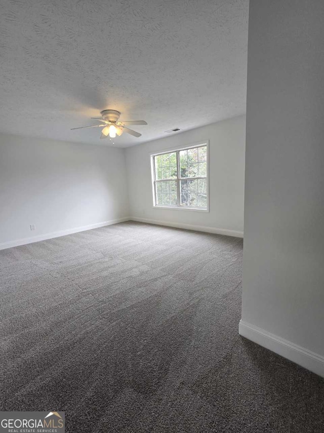 spare room featuring carpet, a textured ceiling, and ceiling fan