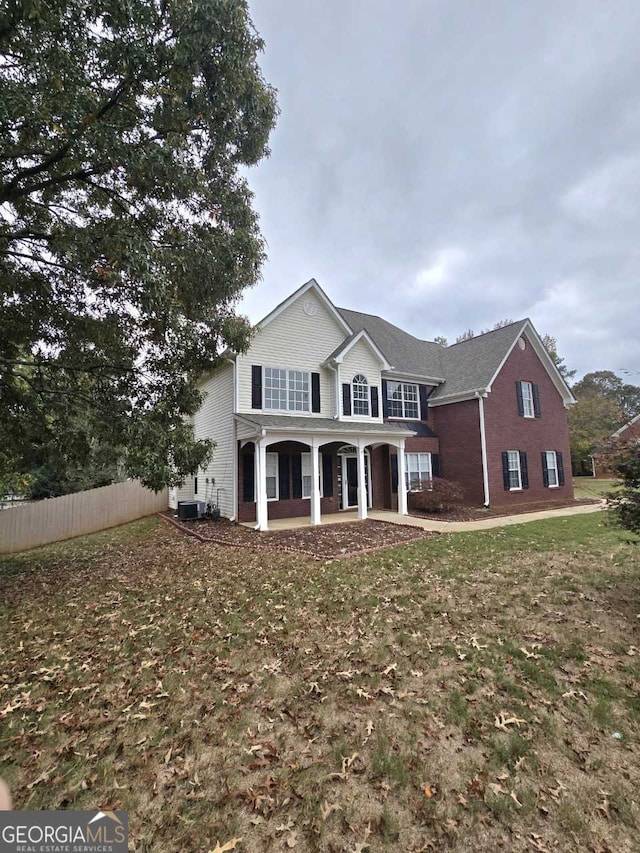 view of front property featuring a front yard and central AC