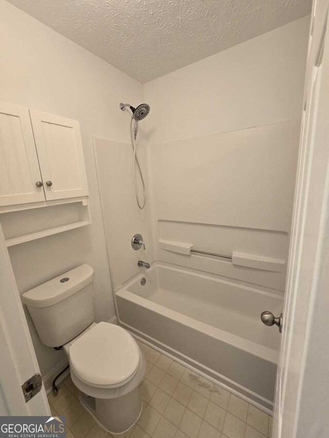 bathroom with toilet, shower / tub combination, a textured ceiling, and tile patterned flooring