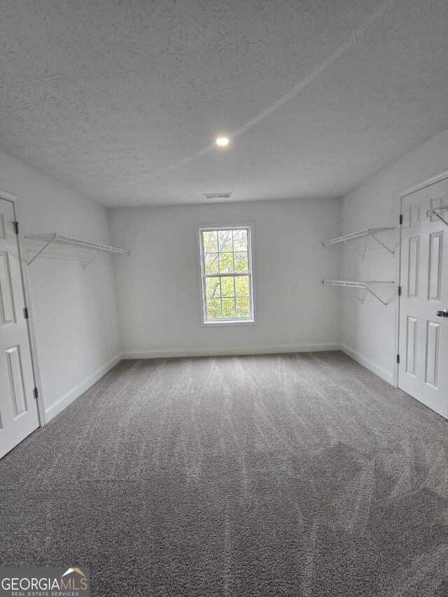 carpeted spare room with a textured ceiling