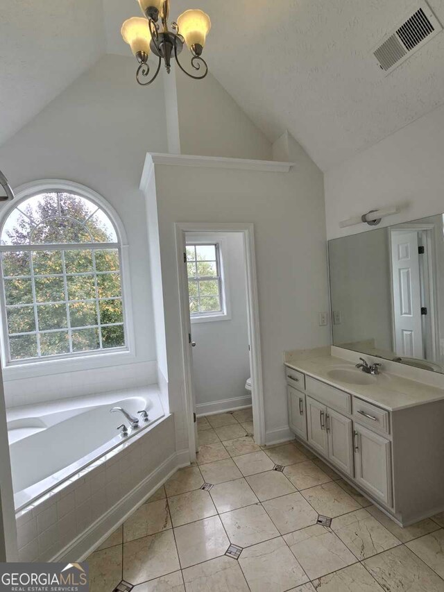 bathroom with lofted ceiling, a notable chandelier, and plenty of natural light