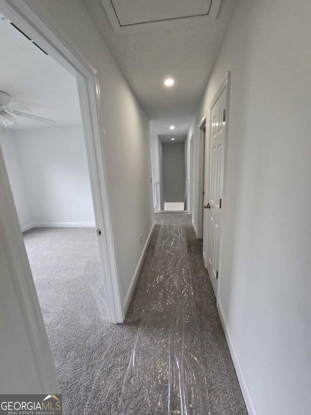 hallway featuring dark carpet