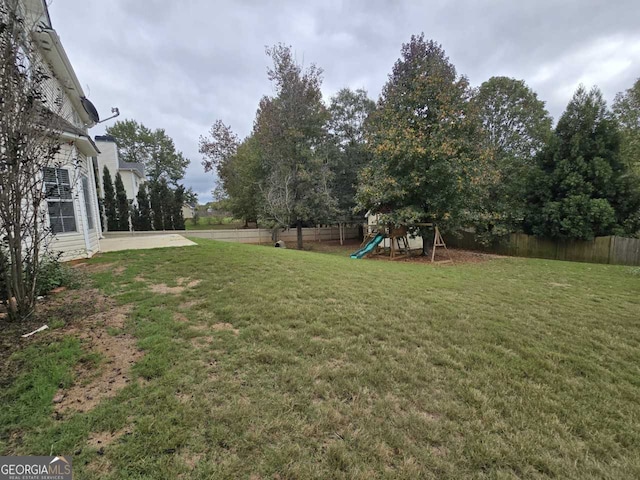 view of yard featuring a playground and a patio