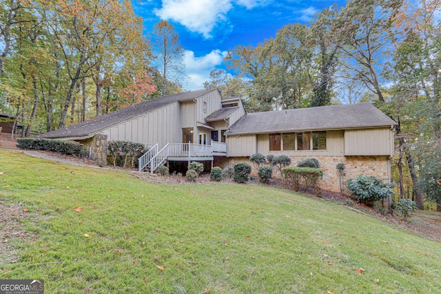 view of front facade featuring a front yard and a wooden deck