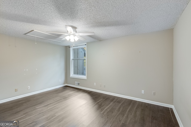 empty room with dark hardwood / wood-style flooring, a textured ceiling, and ceiling fan