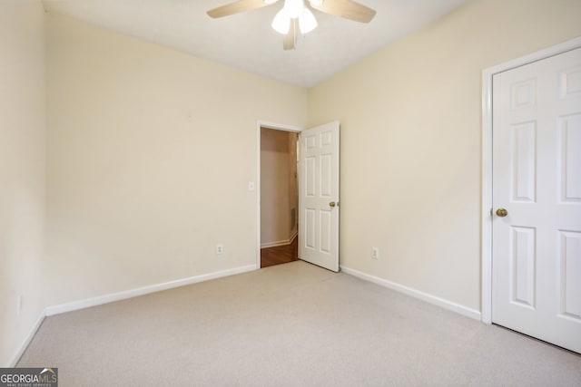 unfurnished bedroom with ceiling fan and light colored carpet