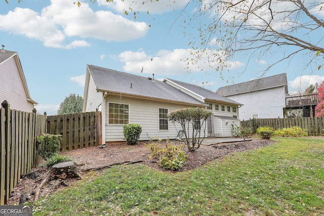 back of house featuring a patio area and a lawn