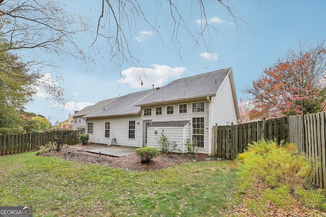 rear view of house featuring a patio area and a yard