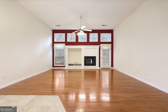 unfurnished living room with ceiling fan and hardwood / wood-style floors