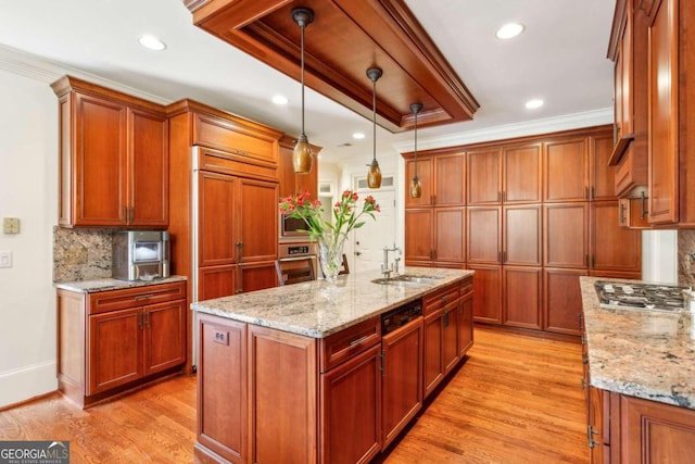 kitchen featuring light stone countertops, appliances with stainless steel finishes, decorative light fixtures, and light hardwood / wood-style flooring