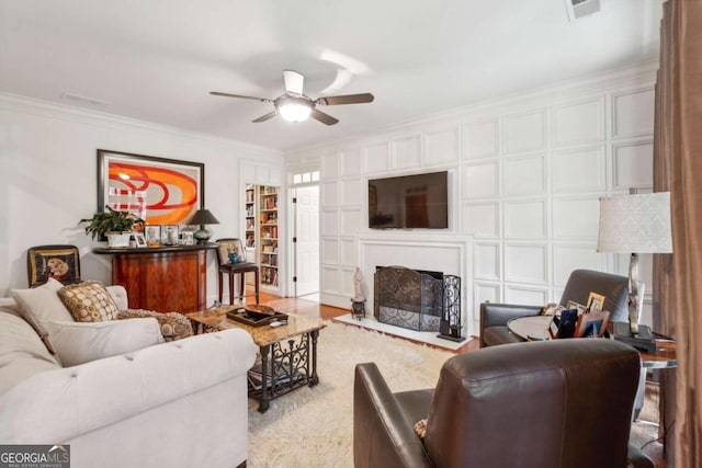 living room with ceiling fan and ornamental molding