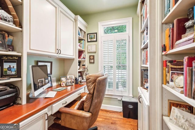 office space with light hardwood / wood-style flooring and built in desk