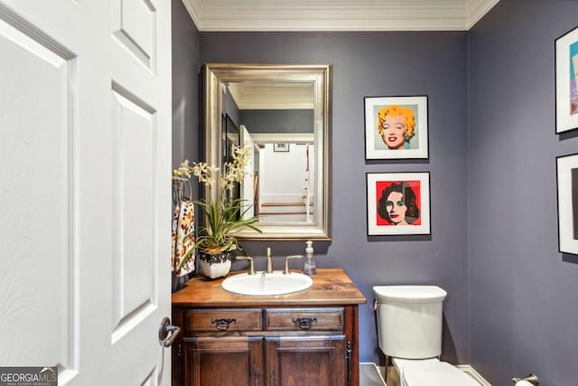 bathroom featuring toilet, vanity, and crown molding