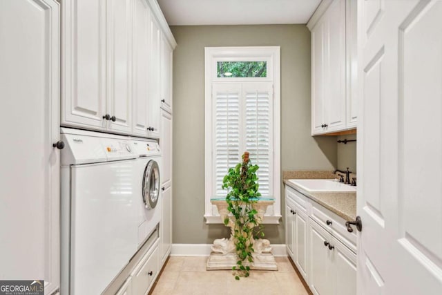 laundry room featuring independent washer and dryer, cabinets, sink, and light tile patterned floors