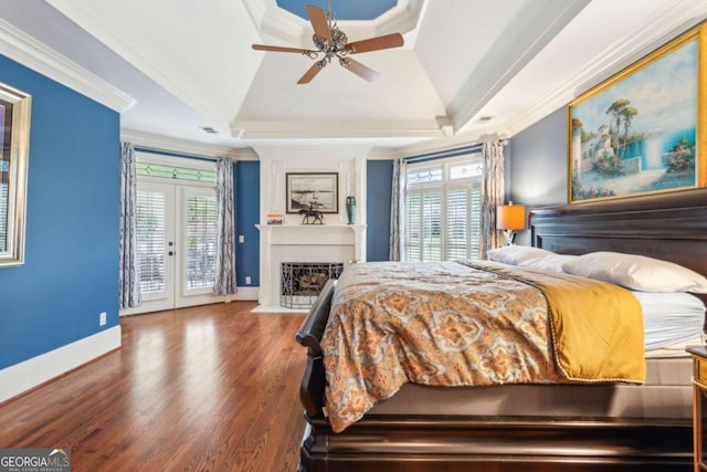 bedroom with a tray ceiling, access to outside, multiple windows, and ornamental molding