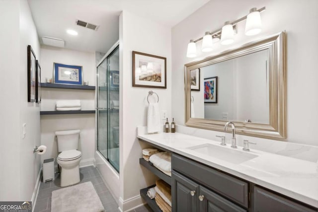 full bathroom with tile patterned flooring, shower / bath combination with glass door, toilet, and vanity