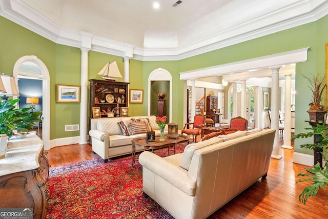 living room featuring ornamental molding, hardwood / wood-style floors, and decorative columns