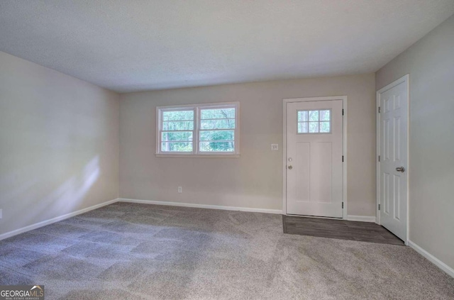 entryway featuring carpet and a textured ceiling