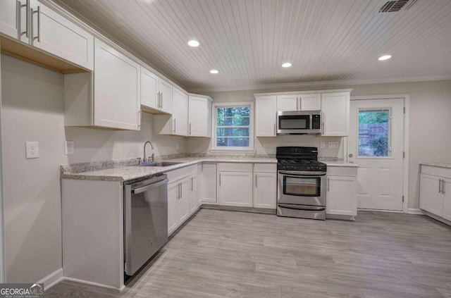 kitchen with stainless steel appliances, light hardwood / wood-style floors, white cabinets, and sink