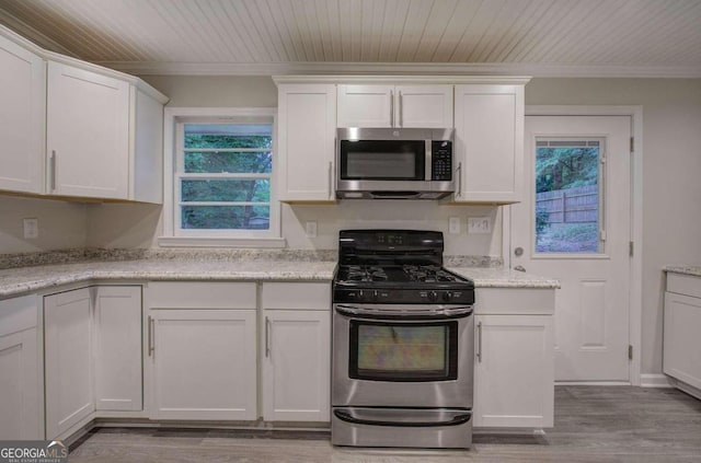 kitchen featuring white cabinetry, appliances with stainless steel finishes, light stone counters, and light hardwood / wood-style flooring