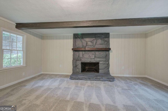 unfurnished living room featuring carpet, a fireplace, a textured ceiling, and beam ceiling