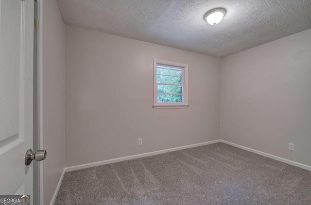 carpeted empty room with a textured ceiling