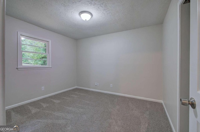 empty room featuring a textured ceiling and carpet