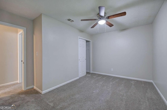 unfurnished bedroom featuring a textured ceiling, carpet floors, ceiling fan, and a closet