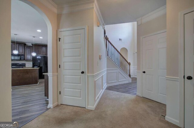 corridor with carpet flooring and ornamental molding