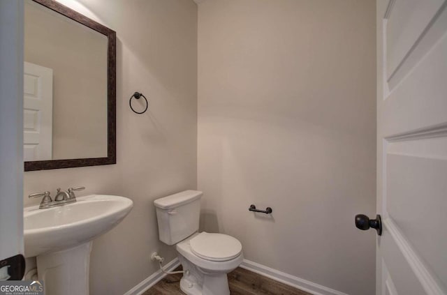 bathroom featuring hardwood / wood-style flooring, sink, and toilet