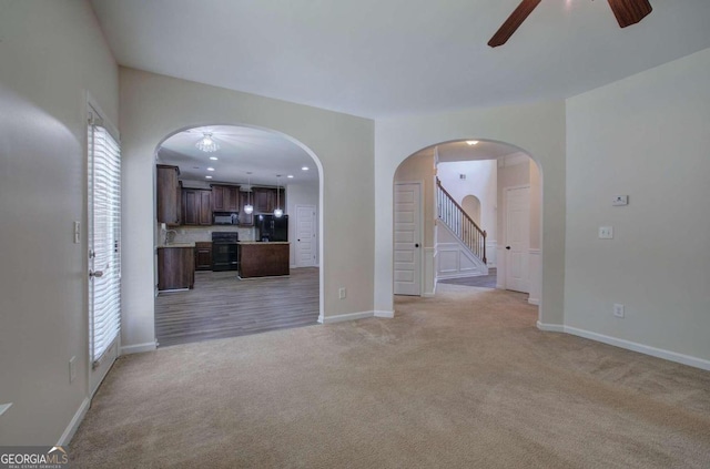 unfurnished room with ceiling fan and light carpet