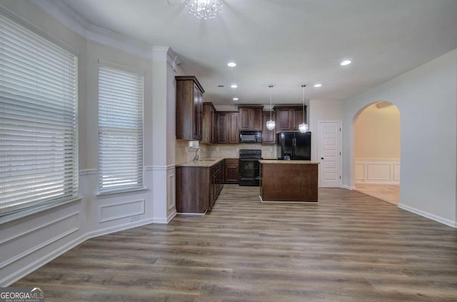 kitchen with black appliances, crown molding, a kitchen island, dark hardwood / wood-style floors, and pendant lighting