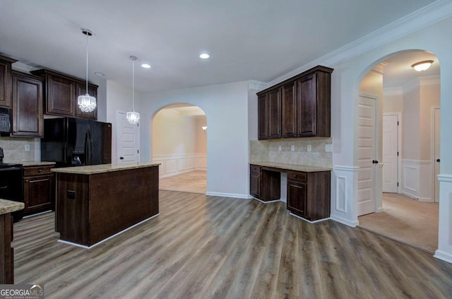 kitchen with black appliances, backsplash, dark brown cabinets, and a center island