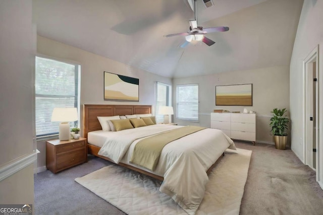 bedroom with ceiling fan, multiple windows, light carpet, and vaulted ceiling