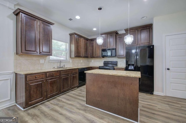 kitchen featuring pendant lighting, light hardwood / wood-style flooring, black appliances, and a center island