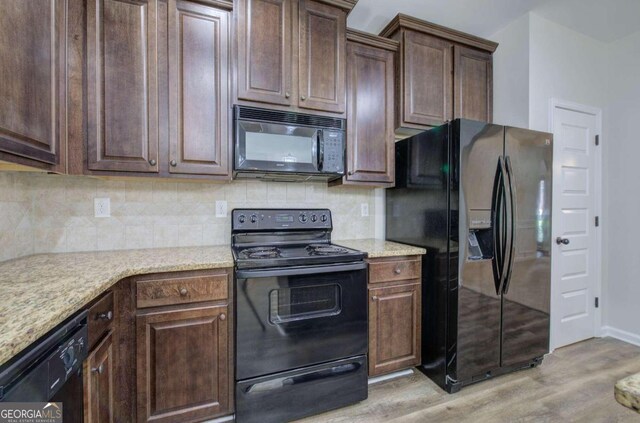 kitchen with decorative backsplash, light hardwood / wood-style floors, and black appliances