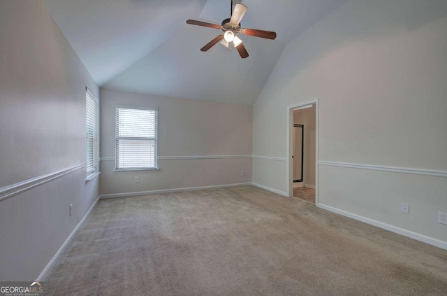 spare room featuring ceiling fan, light carpet, and lofted ceiling