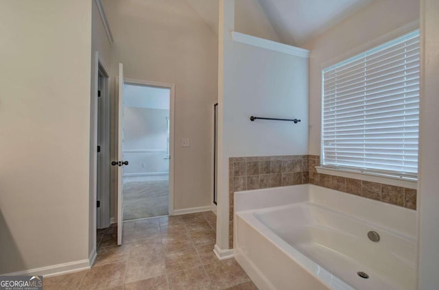 bathroom featuring a bathtub, lofted ceiling, and tile patterned floors