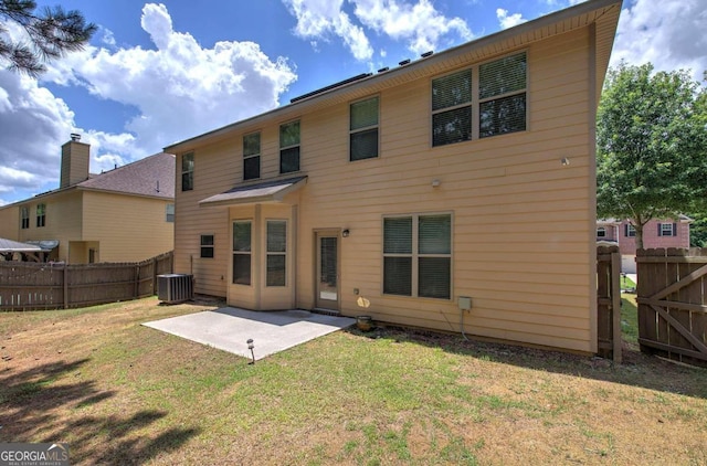 rear view of house with central AC unit, a lawn, and a patio